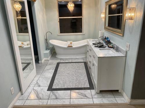 Baño blanco con bañera y lavamanos en Beautiful peaceful desirable home in Madera Rancho en Madera