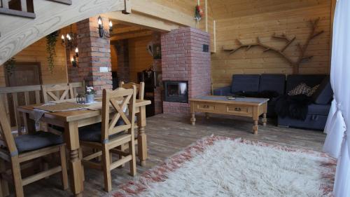 a living room with a table and a fireplace at Stodoła Simonka na punkcie widokowym in Zawoja