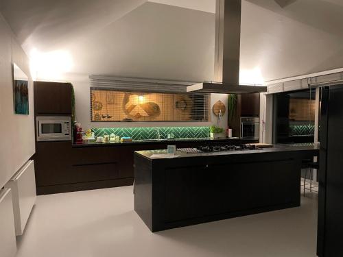uma cozinha com balcões pretos e um fogão forno superior em Luxurious villa during tomorrowland em Hemiksem