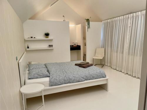 Luxurious villa during tomorrowland في Hemiksem: غرفة نوم بيضاء مع سرير ومكتب