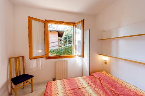 Habitación pequeña con cama y ventana en Villino Garden & Pool, en Andora