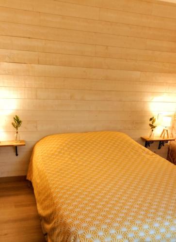 - une chambre avec un lit et deux lampes sur deux tables dans l'établissement Le cottage du Marais., à Houlle