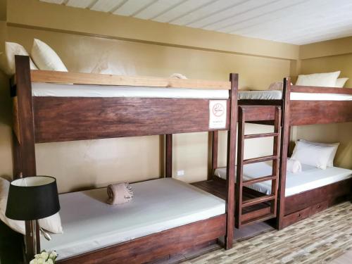 2 łóżka piętrowe w pokoju z lampką w obiekcie Pacific Waves Inn (Annex) w mieście Baler