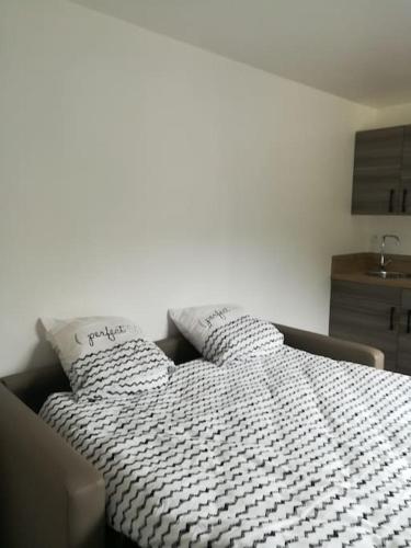 - un lit avec une couette en noir et blanc dans une chambre dans l'établissement studio d'hôtes climatisé, à Floirac