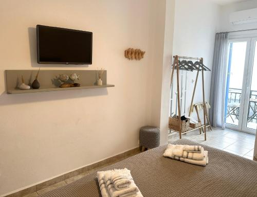 een kamer met een flatscreen-tv aan de muur bij La Main Street suite in Andiparos