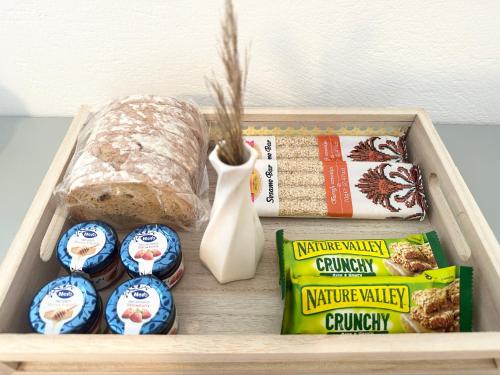 a wooden tray with a box of food and bread at La Main Street suite in Andiparos