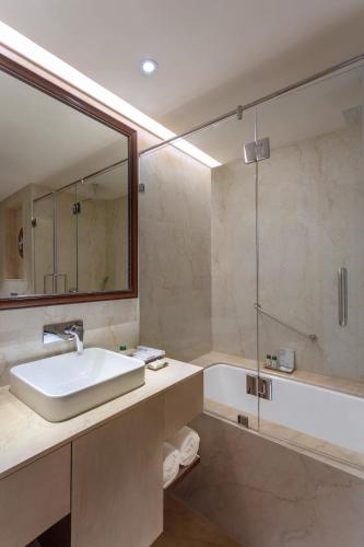 a bathroom with a sink and a mirror and a tub at Fortune Park Pushpanjali, Durgapur - Member ITC Hotels' Group in Durgāpur
