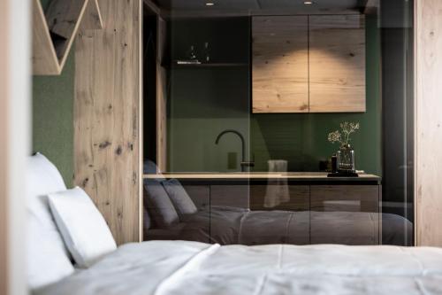 a bedroom with a bed and a kitchen with a sink at Aparthotel My Daum in Nova Ponente