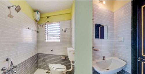 uma casa de banho com um WC e um lavatório em Coronet Luxurious Apartment em Pune