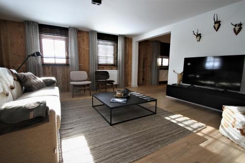 a living room with a couch and a flat screen tv at Alpin Haus Berwang in Berwang