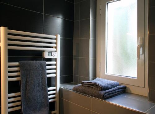 uma casa de banho com uma toalha numa prateleira e uma janela em Appart dans maison 2 km de la plage em Villeneuve-Loubet