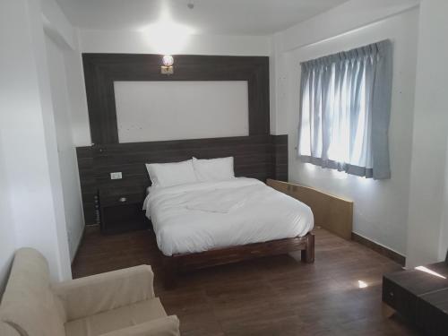 una piccola camera con letto e divano di Everest Guest House a Pokhara