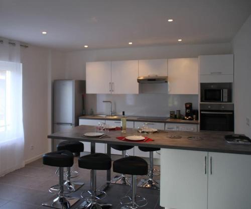 - une cuisine avec un îlot doté de tabourets de bar dans l'établissement Appart dans maison 2 km de la plage, à Villeneuve-Loubet