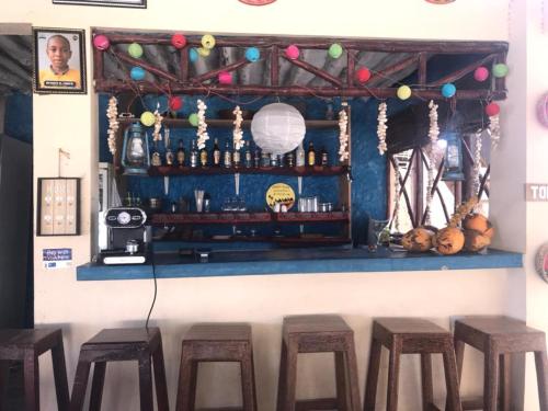 a bar with stools in front of a counter at Mohammed Bungalows and Restaurant in Matemwe