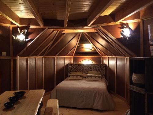 une chambre avec un lit dans une pièce aux murs en bois dans l'établissement Le cul de loup, à Vouzon