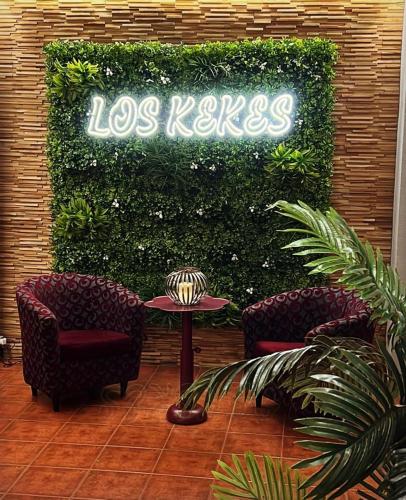 un cartel de los net en un vestíbulo con 2 sillas y una mesa en Hotel Los Kekes, en Coria