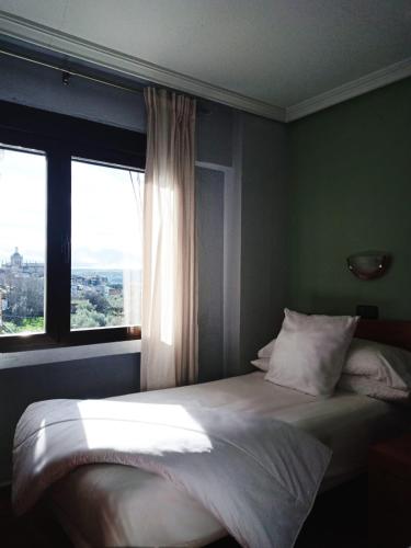 - une chambre avec un grand lit et une fenêtre dans l'établissement Hotel Los Kekes, à Coria