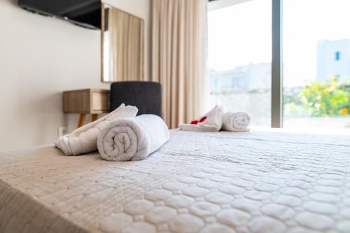 a hotel room with a bed with towels on it at Lilium Apartment in Kos