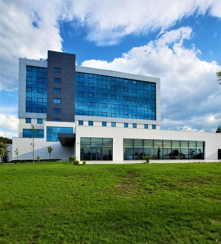 a building with a grass field in front of it at Park Dedeman Denizli in Denizli