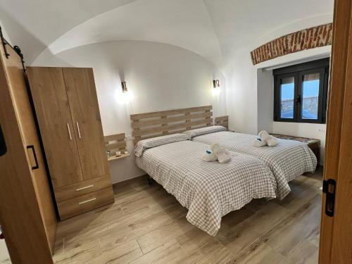 1 dormitorio con 2 camas y suelo de madera en Casa rural Maila en Malpartida de Cáceres