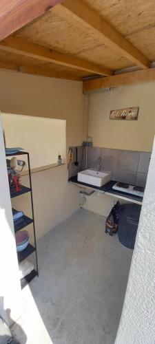 une cuisine avec un évier et une étagère dans une pièce dans l'établissement 15min de disney, dépendance et piscine privée à la campagne, à Crèvecoeur-en Brie