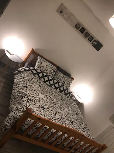 a bed in a bedroom with two lights on the wall at Maisonnette cosy à Châtillon-Coligny in Châtillon-Coligny