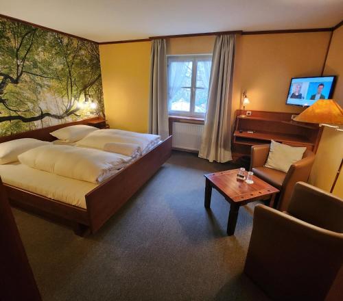 a hotel room with a bed and a couch and a table at Hotel & Restaurant Sonnenhöfle in Sommerhausen