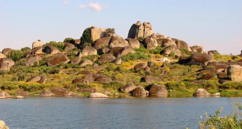 a hill with rocks and a body of water at Casa rural Maila in Malpartida de Cáceres