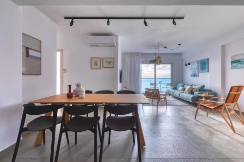 een eetkamer en een woonkamer met een tafel en stoelen bij Stoa apartments in Katávolos