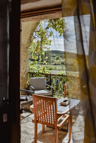 a patio with a table and chairs and a laptop at MAS COURADOU in Labastide-de-Virac