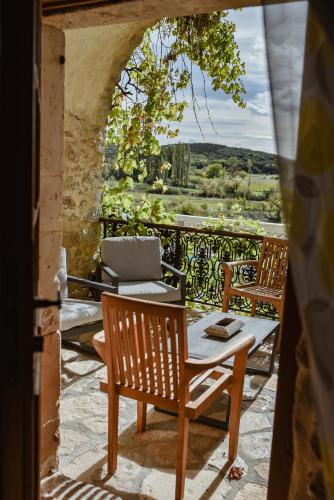 a balcony with a table and chairs and a laptop at MAS COURADOU in Labastide-de-Virac