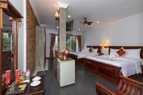 a hotel room with two beds and a table at The Five Senses Boutique Hotel in Siem Reap