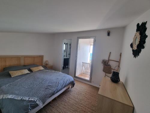 une chambre avec un grand lit et un miroir dans l'établissement Agde : Appartement 2 chambres au bord des falaises, au Cap d'Agde