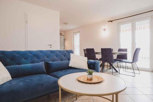 a living room with a blue couch and a table at Holiday home in Klimno - Insel Krk 42238 in Klimno