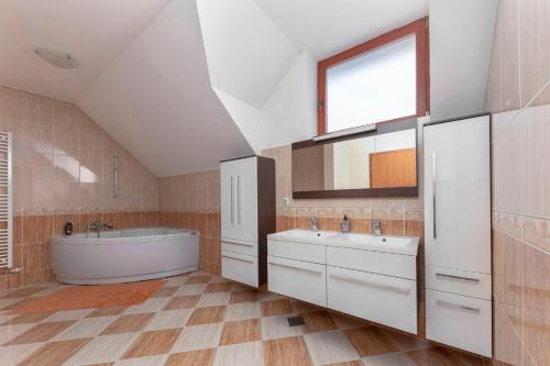 baño con 2 lavabos, bañera y ventana en Apartma Ana, en Preserje