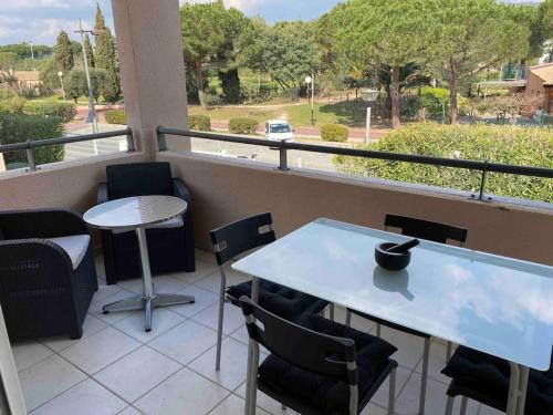 un balcon avec une table et des chaises et une vue dans l'établissement Studio dans résidence piscine 500m de la plage 2**, au Lavandou