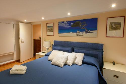 niebieskie łóżko z białymi poduszkami w sypialni w obiekcie Apartment Roma Deluxe w Rzymie