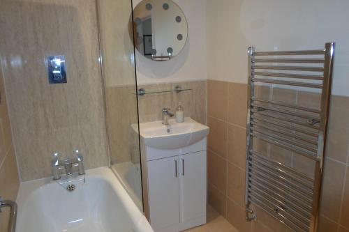 y baño con lavabo y bañera junto a una ducha. en Viking Villa, en Broadstairs