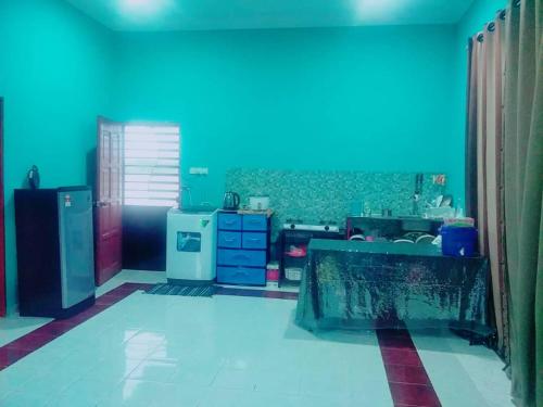 a room with a kitchen with a blue wall at Sobey Laris Homestay KAYDEE in Pasir Mas