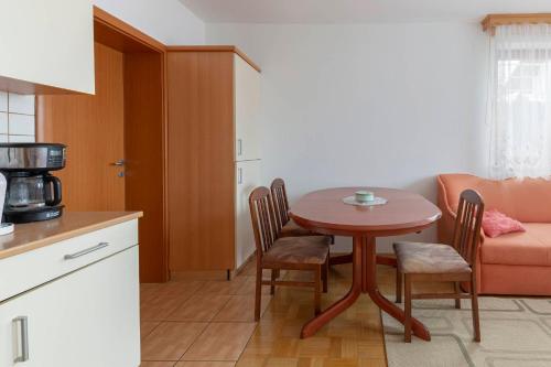 una cucina con tavolo, sedie e un divano di Apartma Ana a Preserje