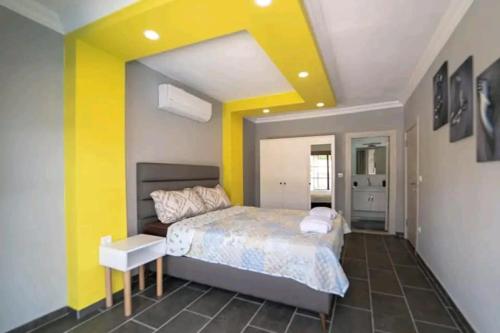 a bedroom with a bed and a yellow wall at Orange Blossom villas in Fethiye