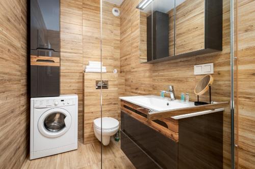 a bathroom with a washing machine and a sink at Apartments 24h in Warsaw