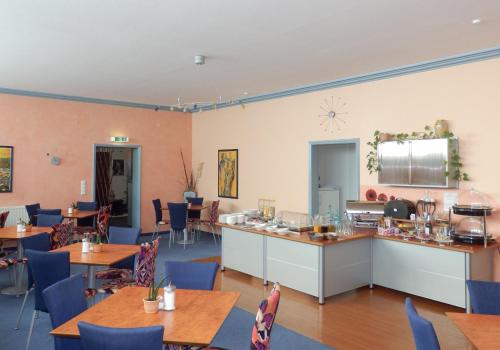 ein Restaurant mit Holztischen und blauen Stühlen in der Unterkunft Park Hotel in Schweinfurt