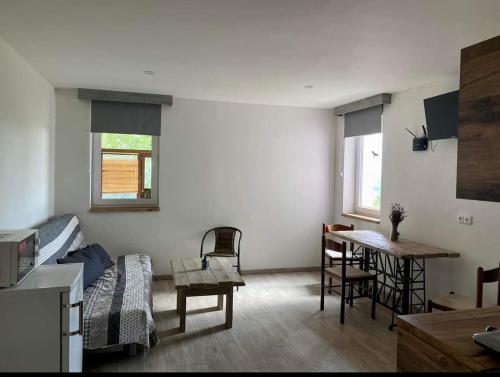 a living room with a bed and a table in it at Apartmány Skala in Příbram