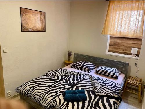 a bedroom with a zebra blanket on a bed at Apartmány Skala in Příbram