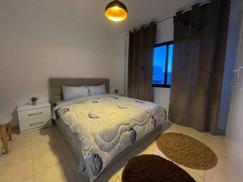 - une chambre avec un lit, une fenêtre et 2 tapis dans l'établissement Apartments Yellow, à Durrës