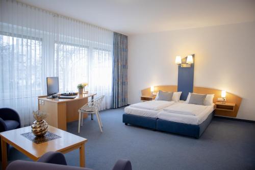 a hotel room with a bed and a desk at Park Hotel in Schweinfurt