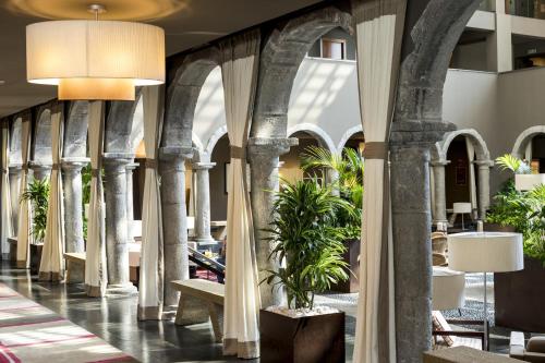 a lobby with columns and plants in a building at Parador De La Seu D'urgell in La Seu d'Urgell