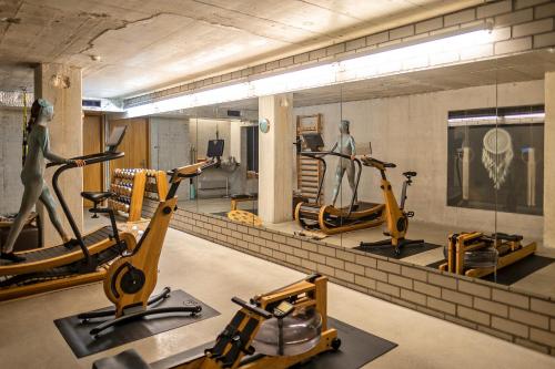 a gym with several exercise bikes and a mirror at Nomad Design & Lifestyle Hotel in Basel