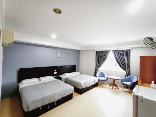 a hotel room with two beds and a table and chairs at Sherwinton hotel Mentakab Town in Mentekab